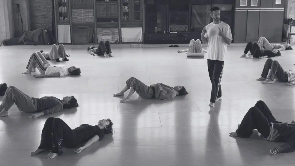 Awareness Through Movement group class, people exploring movement lying on the floor